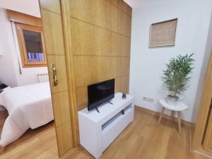 维戈Castrelos, Vigo, diseño的一间白色橱柜上配有电视的卧室