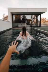 那慕尔Comme chez Lore - villa 2pers - piscine chauffée的女人在房子的游泳池里游泳