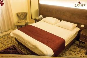 扎赫勒La Place Hotel的配有一张床和一把椅子的酒店客房