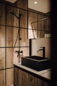 那慕尔Comme chez Lore - villa 2pers - piscine chauffée的一间带黑色水槽和淋浴的浴室
