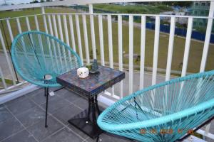 大雅台SMDC Wind Loft Bedroom 101 Facing Amenities with WIFI and Parking的阳台上配有2把蓝色椅子和一张桌子
