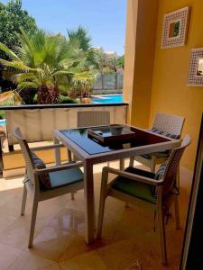 赫尔格达El gouna Ferienwohnung in zentraler Lage的观景阳台配有一张木桌和椅子。