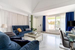 塞维利亚塞维利亚普尔塔赫雷斯站中央套房公寓的客厅配有蓝色的沙发和桌子