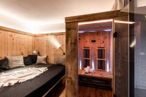 布鲁尼科Bellevue Bruneck - Suites & Lofts的木墙客房的一张床位