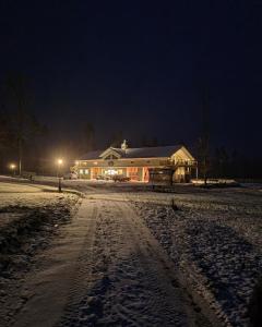 LjungMysig lägenhet med öppen planlösning på hästgård.的夜晚雪中的房子