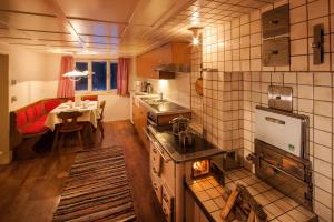 梅劳Alps Hoamat的一间带炉灶的厨房和一间带桌子的用餐室