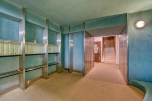 萨奥兹-杜尔克斯Elegante appartamento-100mt dal centro-50mt dalla seggiovia-wifi-parcheggio gratuito的一条空的走廊,有蓝色的墙壁和楼梯