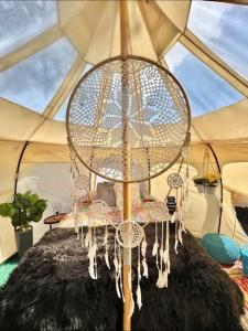 RogersvilleThe Aries-a stargazing, luxury glamping tent的配有吊灯的帐篷内床的房间