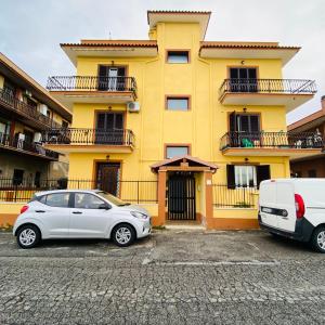 罗马Roma Tor Vergata Luxury House的停在黄色建筑前面的白色汽车