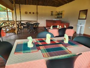 KihihiIshasha Pride Lodge的一间带桌椅的用餐室和一间带桌椅的房间
