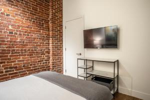 阿什维尔Elevation Lofts Hotel的一间卧室设有一张床和砖墙
