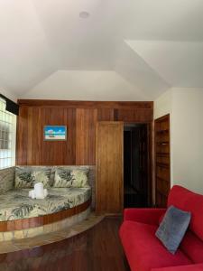 普纳奥亚TAMANU LODGE的客厅配有床和红色沙发