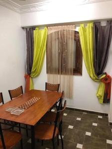 库塞尔Villa Carimo的用餐室配有木桌和黄色窗帘