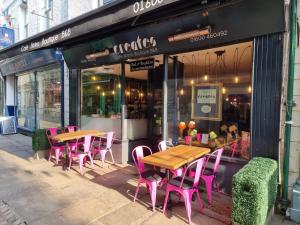 蒙默思Creates的外面设有粉红色的桌椅的餐厅