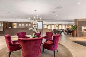 阿兰达公园机场贝斯特韦斯特优质酒店的一间用餐室,配有红色的椅子和桌子