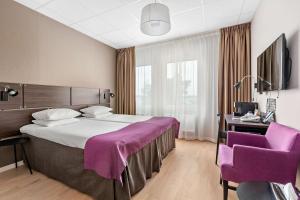 阿兰达公园机场贝斯特韦斯特优质酒店的酒店客房设有一张大床和紫色椅子