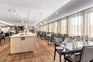 阿兰达公园机场贝斯特韦斯特优质酒店的一间带桌椅的餐厅和一间酒吧