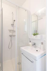 布西圣乔治L'Ensoleillé-T2-56m2-Centre ville 10min Disney的白色的浴室设有水槽和淋浴。