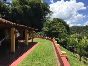 皮尼亚尔齐纽Sítio Vale do Sol的一座花园,花园内有建筑和草地及树木
