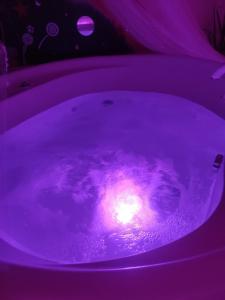 利托梅日采Pension Relax-Hvězdička的紫色的浴缸,里面放着蜡烛