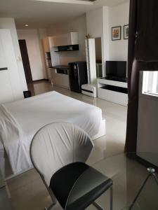 乔木提恩海滩大中天宾馆的卧室配有白色的床和椅子