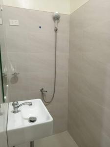 锡基霍尔Avelina Inn的白色的浴室设有水槽和淋浴。
