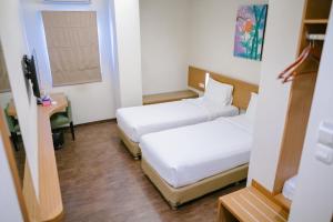安汶Biz Hotel Ambon的酒店客房配有两张床和一张书桌