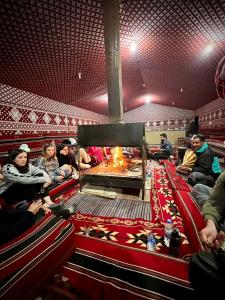 瓦迪拉姆Bedouin Tours Camp的一群人坐在一个带壁炉的剧院里