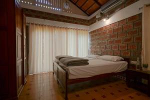 MurinjupuzhaEkantha Ala的一间卧室设有一张床和砖墙