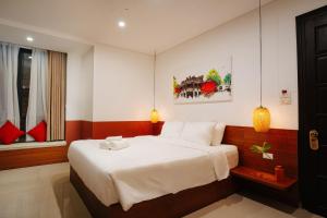 会安Hoianese Center Hotel - Truly Hoi An的一间卧室配有一张带白色床单的大床