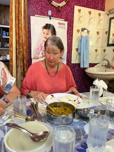 布莱尔港Abhi's homestay的坐在餐桌上吃一盘食物的女人