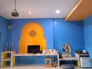 拉差汶里The Sun resort Ratchaburi的一间设有一张书桌的蓝色和黄色墙壁客房