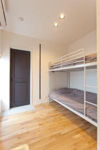 镰仓市CASA Kamakura Espresso&BED的一间卧室设有双层床,铺有木地板。