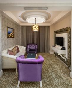 苏莱曼尼亚Ramada by Wyndham - Sulaymaniyah Salim Street的客厅配有紫色沙发和镜子
