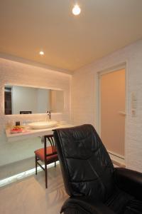 旭川旭川ホテルリップローズ-大人専用的一张黑色皮椅,位于带水槽的房间