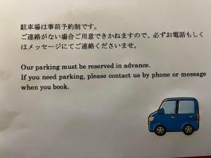 指宿市ゲストハウスまちかど Guest House MACHIKADO的带有小蓝色汽车图纸的标志