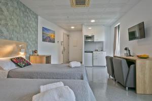 贝古斯Les Begues Apartments的酒店客房带两张床和厨房
