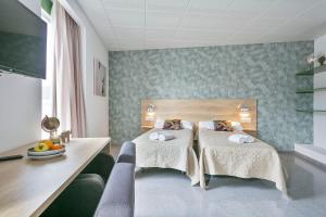 贝古斯Les Begues Apartments的酒店客房配有两张床和一张书桌