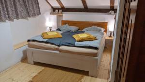 Chajdaloupka的一间卧室配有一张带两张黄色毛巾的床