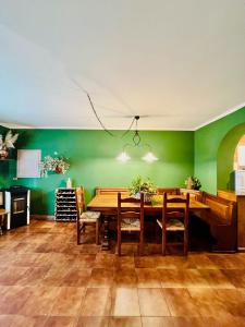 富切基奥Cottage 3138的一间设有木桌和绿色墙壁的用餐室