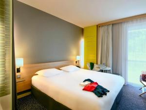 雷泽南特雷泽机场宜必思尚品酒店的一间设有大床和窗户的酒店客房