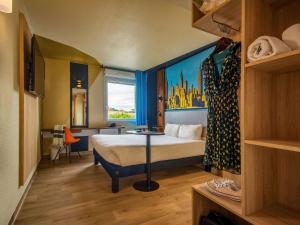 布拉尼亚克图卢兹机场宜必思尚品酒店的酒店客房设有床和窗户。