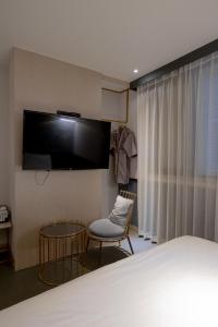 釜山西面 - 北昌杭德酒店的一间卧室配有一张床、一台电视和一把椅子