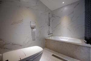 釜山西面 - 北昌杭德酒店的白色的浴室设有浴缸和卫生间。