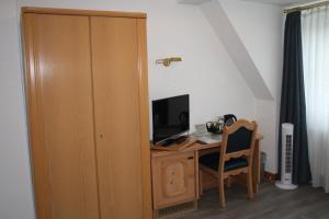 伦讷施塔特Pension / Ferienwohnung Allebrodt的客房设有书桌、电脑和电视。