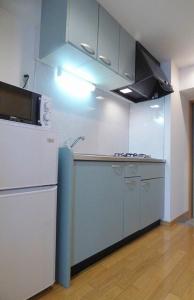 福冈博多駅東貸切Hakataekihigashi Apartment LOFT付き高速WIFI 敷地内駐車場 地下鉄5分 国際線博多駅徒歩圏内的厨房配有白色冰箱和炉灶。