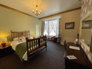 惠特比The Captain's Lodge accommodation的一间卧室配有一张床、一把椅子和一张桌子