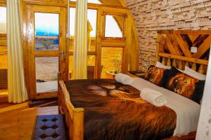 安博塞利Amanya King Lion 1-Bed Wigwam in Amboseli的一间卧室配有一张带狗毯的大型木床