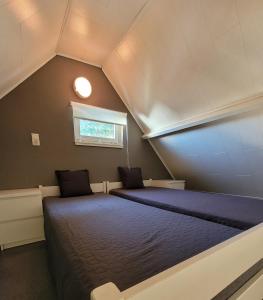科克赛德Vakantiehuis 6 pers, Oostduinkerke aan zee的阁楼上的卧室配有两张床