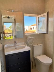 圣米格尔德阿沃纳Juangy’s Apartments in Las Adelfas Golf del Sur的一间带水槽、卫生间和镜子的浴室